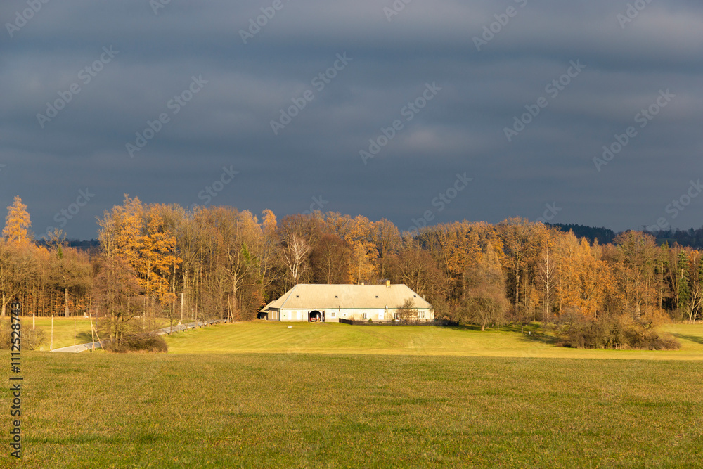 A countryside house at the edge of a field on an autumn evening.