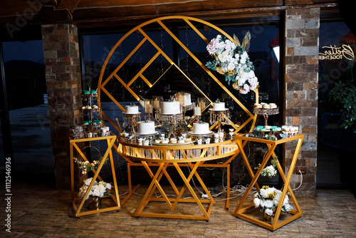 Sweet wedding table, there is a lot of delicious food on it, the cake is in the middle, and there is a lot of sweets around. photo