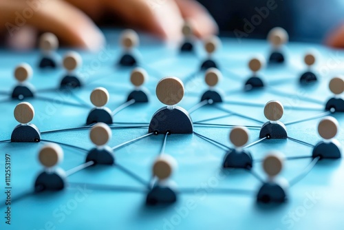 Network connections concept with wooden figurines representing people connected by strings on a blue workspace, illustrating collaboration and communication photo