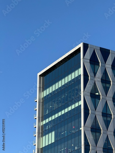 Looking up at modern buildings in Salford Quays with a clear blue sky background. 