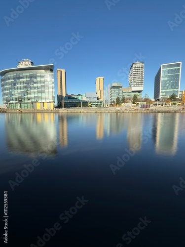 Canvas Print Modern buildings and landmarks next to the water with a clear blue sky background
