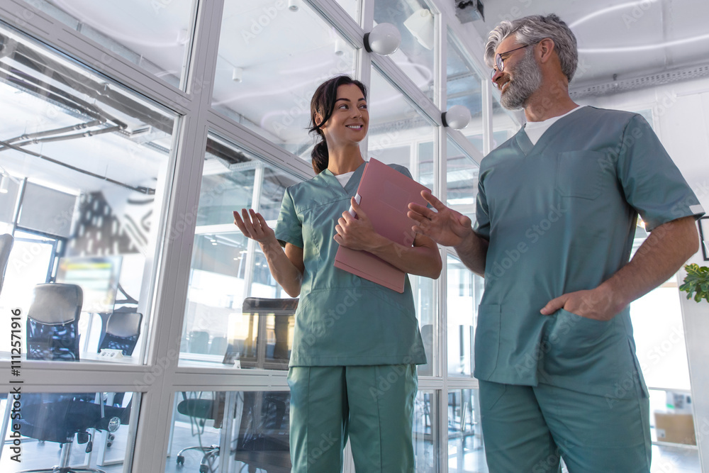 Fototapeta premium Two doctors walking in the clinic corridor and talking