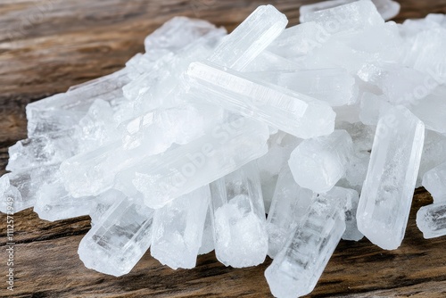 Close-up of transparent crystalline menthol crystals stacked on a wooden surface, showcasing their natural purity and texture. photo