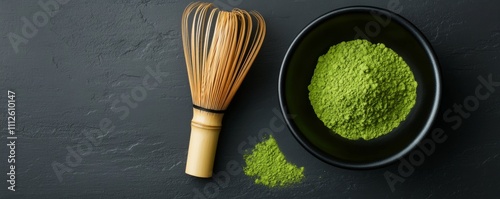 Matcha tea powder heap in a bowl, bamboo whisk on a dark concrete background. Traditional accessories for tea ceremony. Beverage made from finely ground green tea. High antioxidants. Japanese drink