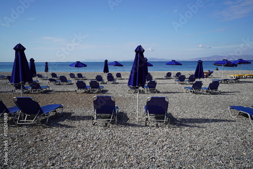 blue sunbeds and umbrellas on the beach of Rhodes town photo