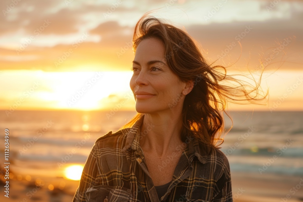 Portrait of a content caucasian woman in her 40s dressed in a relaxed flannel shirt while standing against beautiful beach sunset Portrait of a content caucasian woman in her 40s dressed in a relaxed flannel shirt while standing against beautiful beach sunset