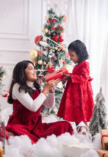 Smiling woman and child sharing a joyful moment while opening presents, Christmas celebration concept image