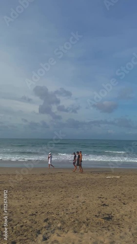 People Walking Along Bali’s Beach Waves