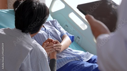 Asian patient female and male listen to doctor in hospital room. husband holding hand wife focused on examination results, health care support medical examination, professional services business