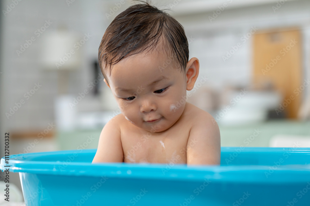 Asian baby taking a bath in a blue tub at home. Asian baby taking a bath in a blue tub at home.
