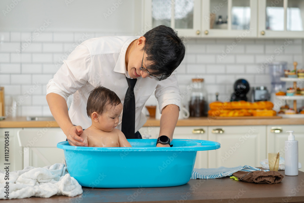 Asian baby taking a bath in a blue tub at home. Asian baby taking a bath in a blue tub at home.
