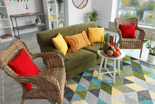 Interior of living room with green sofa, candles and food for Kwanzaa celebration on table photo