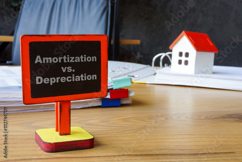 Amortization vs depreciation. Model house symbolizing accounting concept.