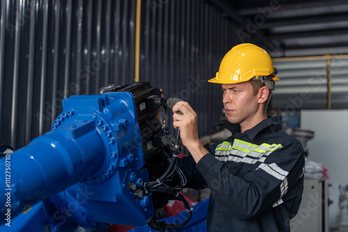 Engineer standing by robotic arm and operating machine in industry factory, technician worker check for repair maintenance electronic operation photo