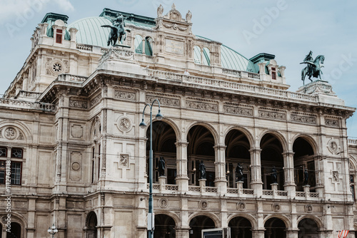 Fachada de la Ópera Estatal de Viena, un edificio monumental de estilo renacentista con columnas corintias, detalles ornamentales y una gran entrada central. photo