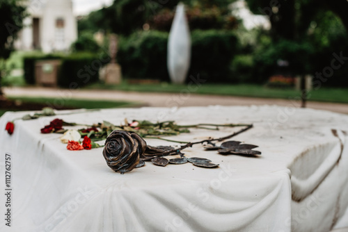 Detalle de la tumba de Udo Jurgens en el cementerio central de Viena Friedhof. En primer plano una rosa negra sobre una superficie de mármol blanco.