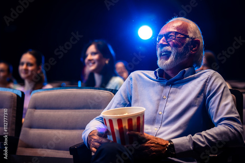 Foto Older man enjoying retirement in the cinema by watching a movie.