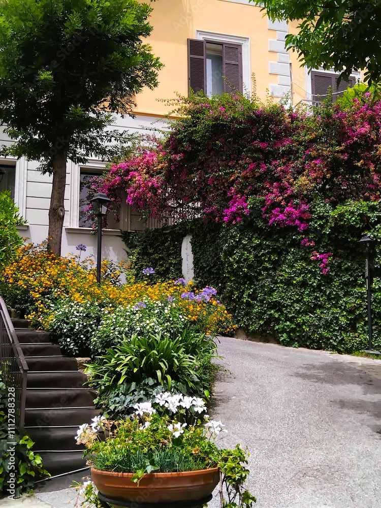 Naklejka premium Beautiful residential courtyard with flowers, green hedge and stairs