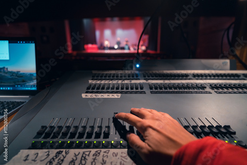 Theater Lighting Control Desk in Action with Hand Adjusting