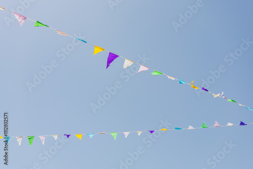Colorful triangular pennant flags against clear blue sky