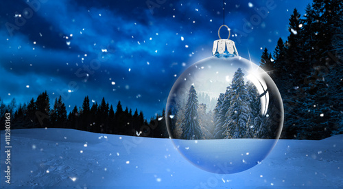 Gläserne Weihnachtskugel vor verschneitem Winterwald