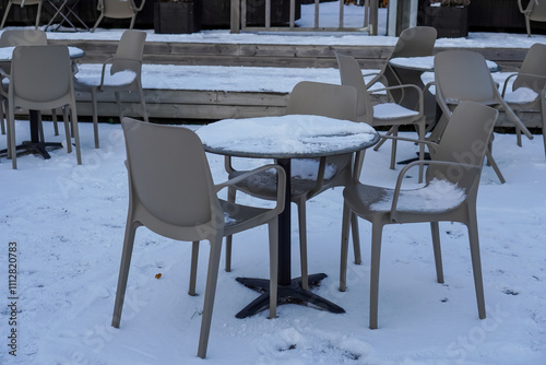 Winter setting with chairs and tables covered in snow at Noblessner harbor in Tallinn, Estonia in 2024 photo