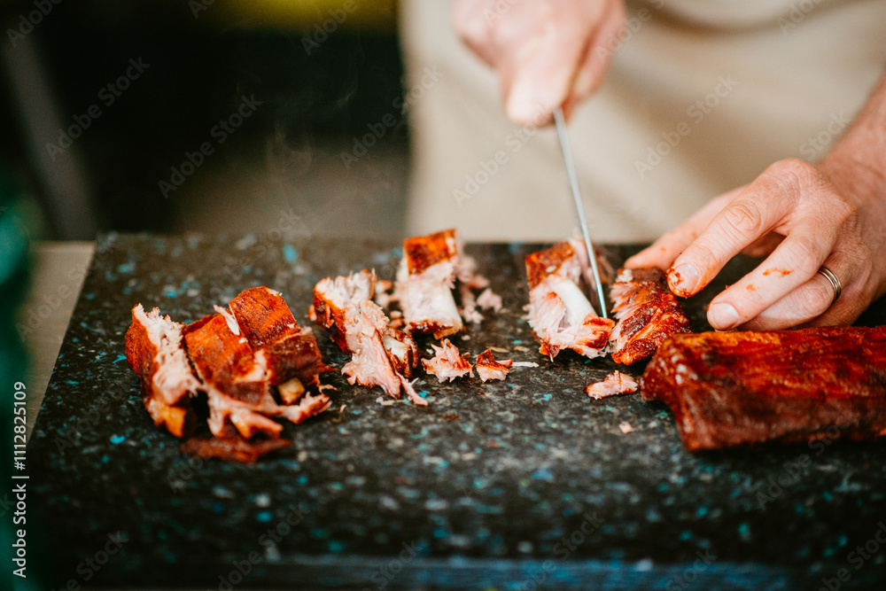 chef slicing smoked meat on black cutting board with precision chef slicing smoked meat on black cutting board with precision