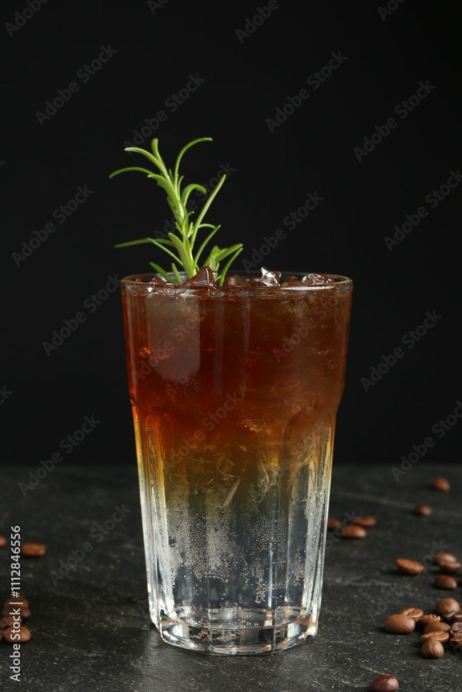 Refreshing espresso tonic drink with rosemary and coffee beans on dark table Refreshing espresso tonic drink with rosemary and coffee beans on dark table