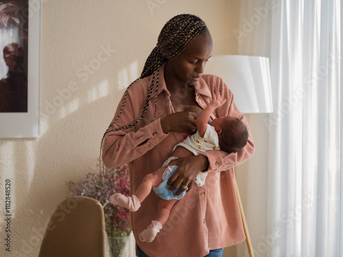 Stressed mother helping to baby to find nipple while breastfeeding