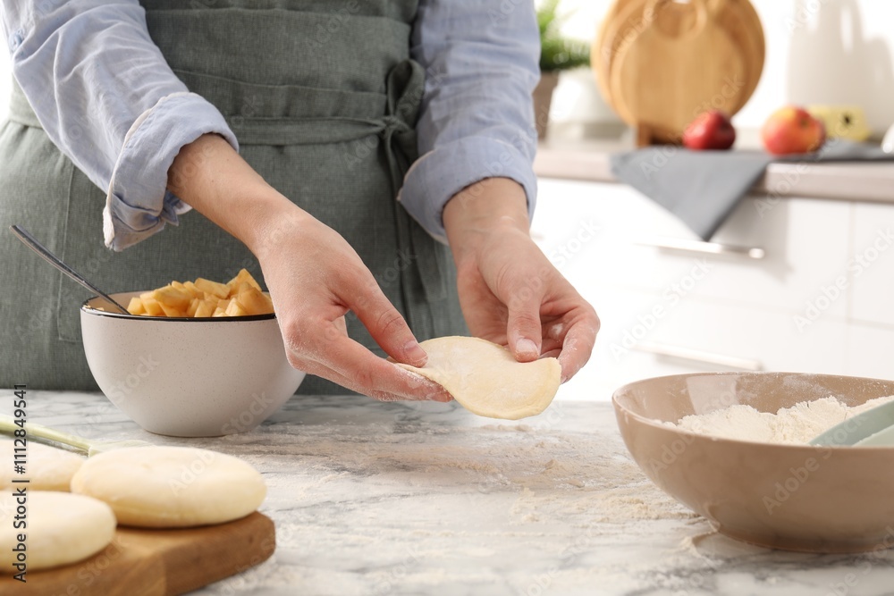 Woman making pirozhki (stuffed pastry pies) at white marble table indoors, closeup Woman making pirozhki (stuffed pastry pies) at white marble table indoors, closeup