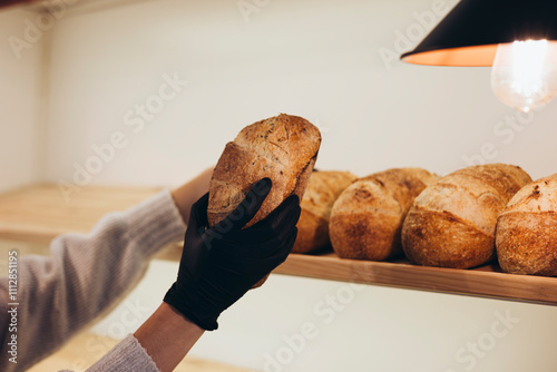 Freshly Baked Bread Displayed on Wooden Shelves in Bakery photo