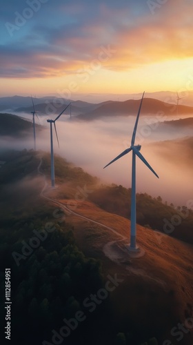 Wind turbines generate renewable energy at sunrise in a misty landscape