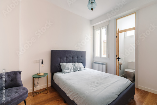 Minimalist bedroom with double bed and a small en-suite bathroom