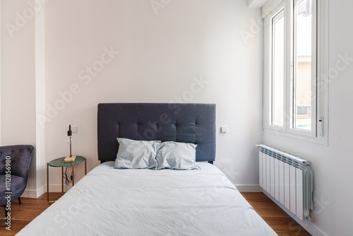 A minimalist bedroom with a neatly made bed photo