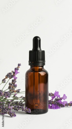 Lavender essential oil bottle placed among fresh lavender flowers on a white ...