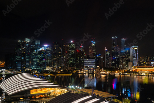 A nighttime view of a cityscape with illuminated skyscrapers photo