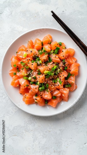 Salmon sashimi with sesame seeds and green onions served on a textured plate