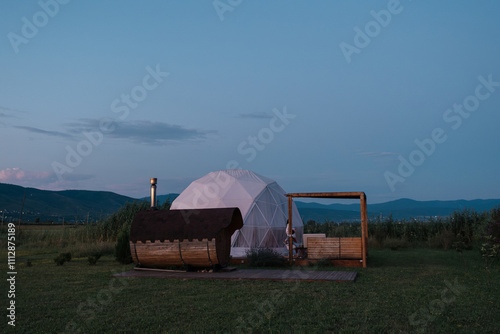 Cozy dome structure with bathhouse in tranquil landscape at dusk photo