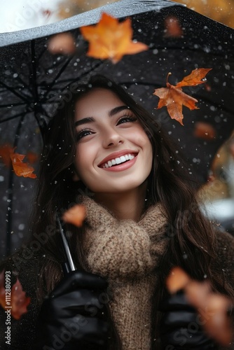 Young woman smiles under umbrella during autumn rain while leaves fall around