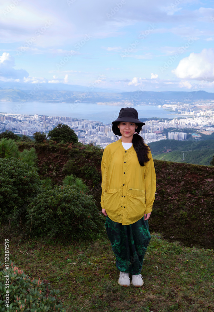 Asian girl on a mountain with a panoramic view of the city background Asian girl on a mountain with a panoramic view of the city background