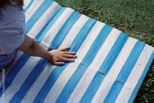 Lady sitting on a matching blue mat in the park. Hi-res film scan