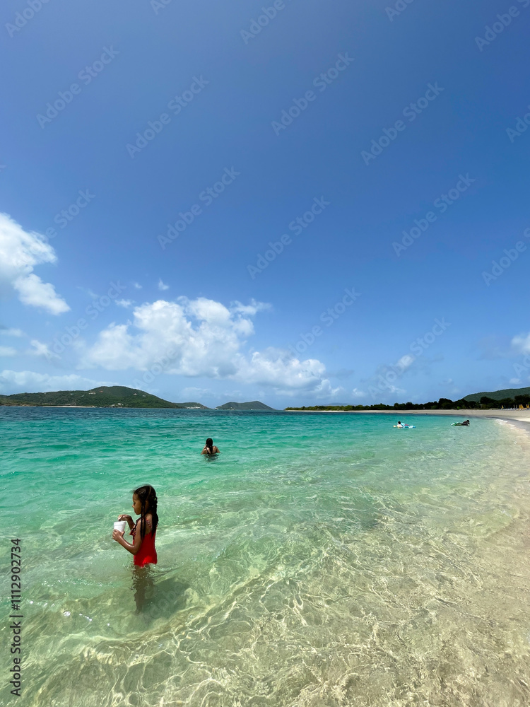 Child standing in the clean ocean water on a beautiful beach Child standing in the clean ocean water on a beautiful beach