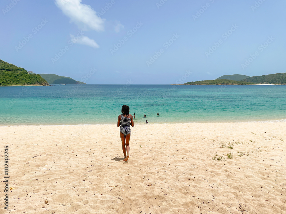 Child walking along a wide tropical vibrant beach Child walking along a wide tropical vibrant beach