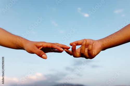 Crop female hands touching in sunset photo