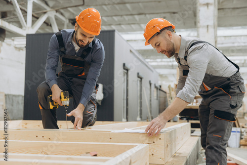Foto Construction workers building wooden frame in factory for modular building