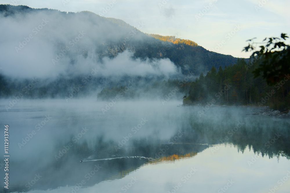 Mystic lake in Alps covered with fog in autumn Mystic lake in Alps covered with fog in autumn