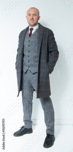 A modern corporate man in a tailored tweed three piece suit. Grey tweed knit business suit for lawyers, bankers and for men with high power positions. Corporate barrister and peaky blinders cos play. photo