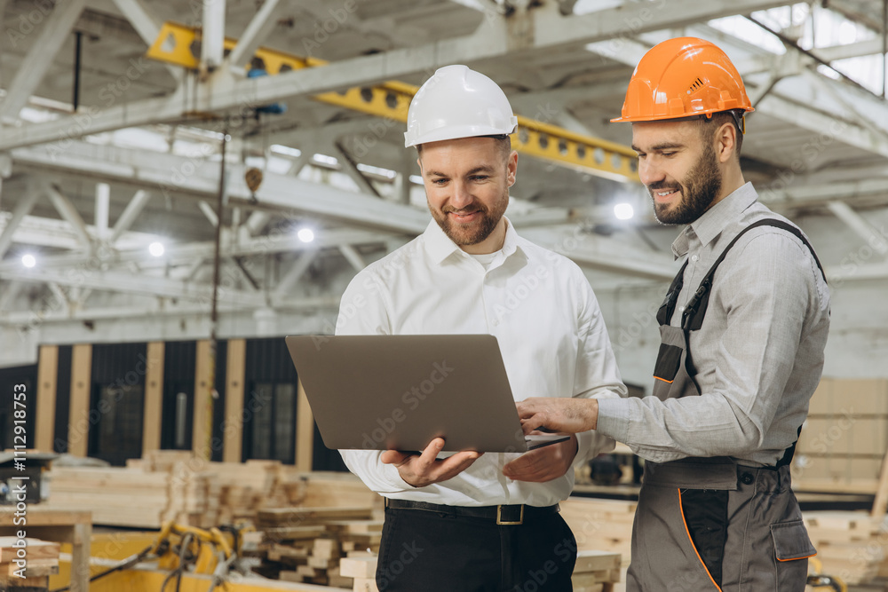 Engineers using laptop, inspecting prefabricated house in modular building factory Engineers using laptop, inspecting prefabricated house in modular building factory