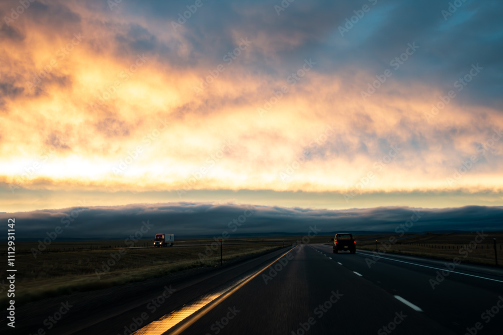 A view of an open highway at sunset with vehicles traveling beneath glowing clouds on the horizon.
A view of an open highway at sunset with vehicles traveling beneath glowing clouds on the horizon.