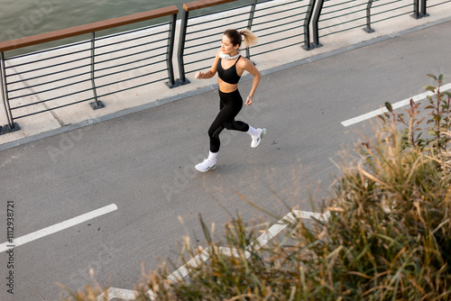 Runner enjoying a morning jog along the waterfront promenade in an urban setting